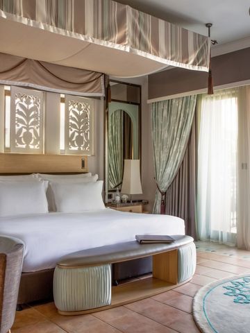 Geräumiges Zimmer mit King-Size-Bett, elegantem Dekor und Balkonzugang.