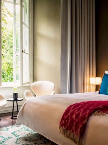 Helles Hotelzimmer mit großen Fenstern und eleganter Einrichtung