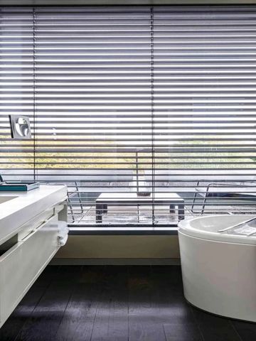 Geräumiges Badezimmer mit Fenster und eleganter freistehender Badewanne