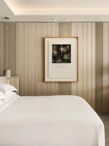 Schlichtes Zimmer mit Holzverkleidung und dezentem Kunstwerk
