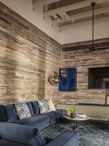 Moderne Lounge mit dunkelblauen Sofas und Holzvertäfelung an den Wänden