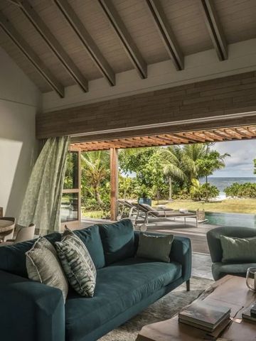 Wohnbereich mit offenem Blick auf Terrasse und Pool unter Palmen
