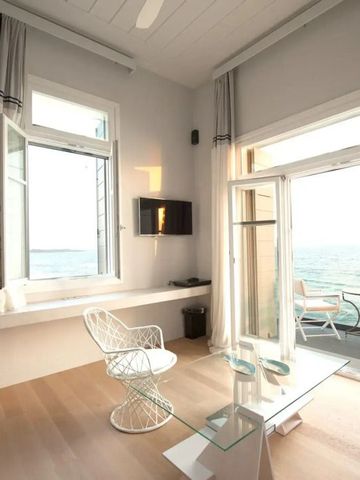 Helles Zimmer im Dexamenes Seaside Hotel mit Blick auf das Meer und Balkon.