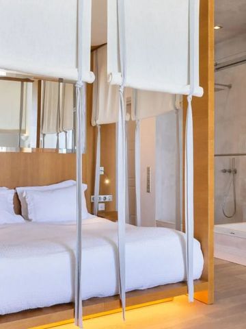 Luxuriöses Schlafzimmer im Dexamenes Seaside Hotel mit modernem Design und Hängeschaukeln.