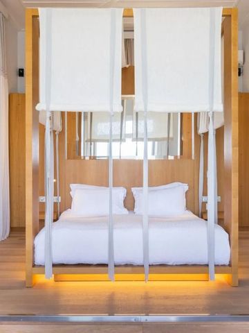 Elegant eingerichtetes Schlafzimmer im Dexamenes Seaside Hotel mit hängenden Schaukeln.