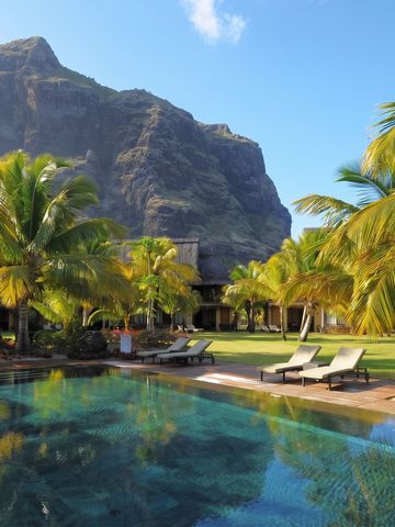 Infinity-Pool mit Liegen und Berg im Hintergrund