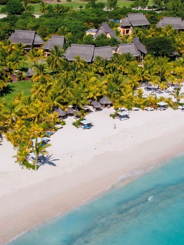 Strand mit Palmen und Villen im Hintergrund