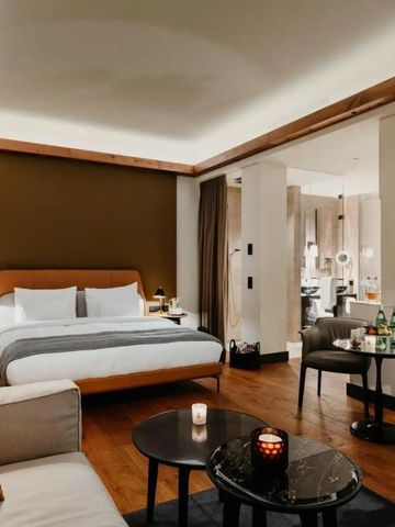 Geräumiges Hotelzimmer mit gemütlicher Sitzecke und eleganter Bettgestaltung