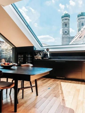Heller Essbereich mit Blick auf Münchner Kirchtürme durch Dachfenster