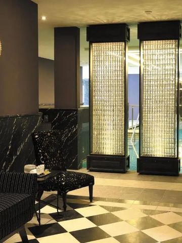 Luxuriöse Spa-Lounge mit gepolsterten Sesseln und beleuchteten Wänden