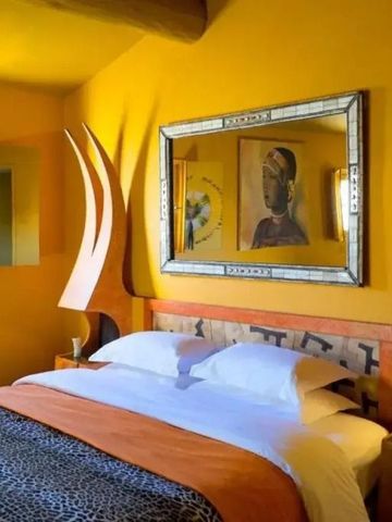 Einzigartig gestaltetes Schlafzimmer mit Kunstwerken und gelben Wänden im Hotel Domaine des Andeols