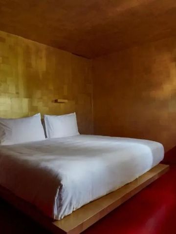 Minimalistisches Schlafzimmer mit goldenem Wanddesign und gemütlichem Bett im Hotel Domaine des Andeols