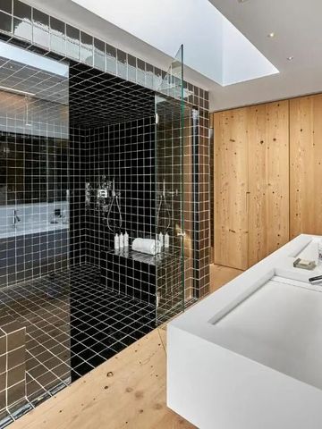 Modernes Badezimmer mit Glasdusche und Holzwänden