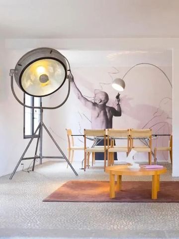 Kunstvoll eingerichteter Raum mit großer Stehlampe und Wandkunst