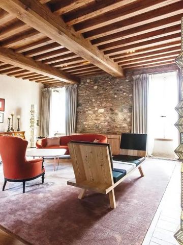 Geschmackvoll eingerichtetes Wohnzimmer mit Holzdecke und roten Sesseln im Hotel Domaine des Etangs
