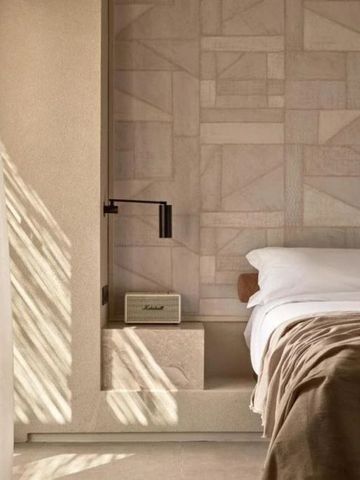 Modernes Schlafzimmer mit geometrischer Wandverkleidung und natürlichem Licht.