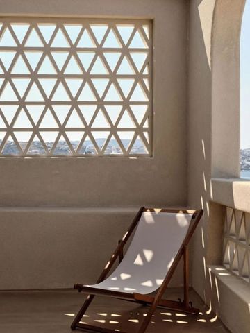 Sonniger Balkon mit Liegestuhl und Meerblick im Domes Noruz Mykonos