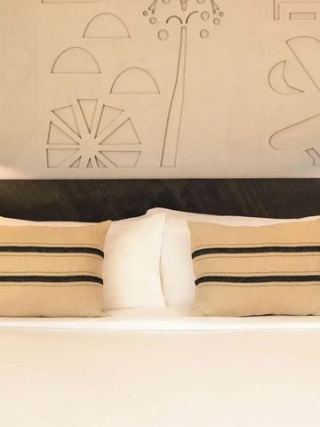 Gemütliches Bett mit dekorativen Kissen und stilvollem Kopfteil