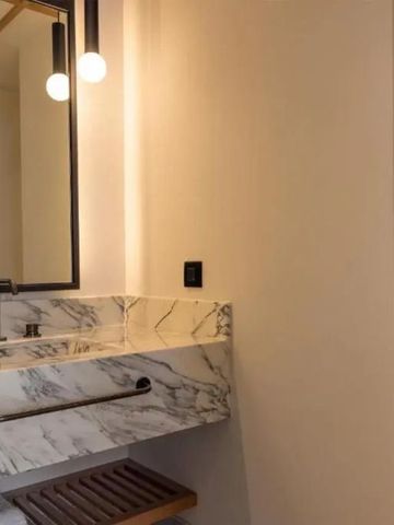 Luxuriöses Badezimmer mit Marmordetails und stilvoller Beleuchtung