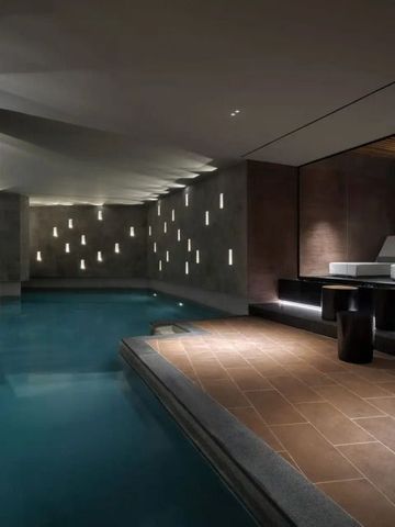 Eleganter Innenpool mit stilvoller Beleuchtung und Liegebereich