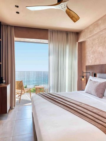 Zimmer mit großem Bett und Balkon mit Meerblick
