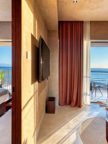 Geräumiges Hotelzimmer mit Meerblick und modernen Möbeln.