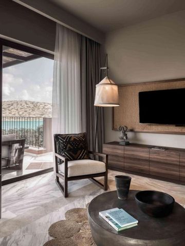 Wohnbereich einer Suite mit Blick auf Terrasse und Meer.