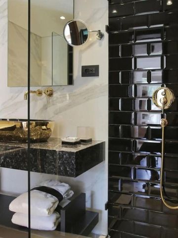 Stilvolles Badezimmer mit goldenen Armaturen und moderner Dusche