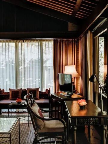 Elegant eingerichtetes Wohnzimmer mit großen Fenstern und stilvollen Dekorationen.
