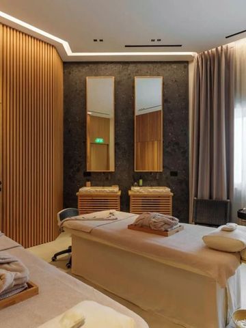 Moderner Spa-Bereich mit zwei Massagetischen und stilvoller Holzwandverkleidung