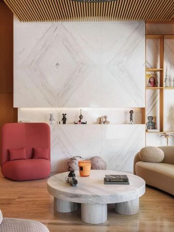 Elegante Lounge mit Designermöbeln in warmen Erdtönen und Marmordetails