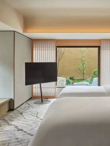 Geräumiges Doppelzimmer mit zwei Betten und Blick in einen Zen-Garten