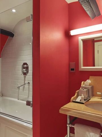 Hotelbadezimmer mit roten Wänden und stilvoller Ausstattung
