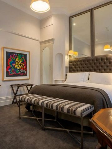 Stilvoll eingerichtetes Schlafzimmer mit Kunst an der Wand