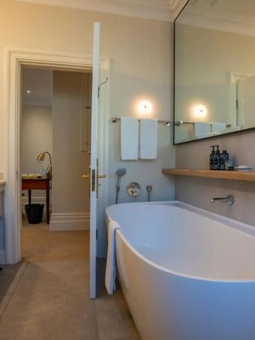 Elegantes Badezimmer mit freistehender Badewanne und großem Spiegel