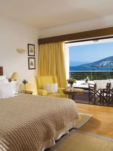 Zimmer mit Doppelbett und Meerblick, gelbes Interieur, Balkon mit Sitzbereich.