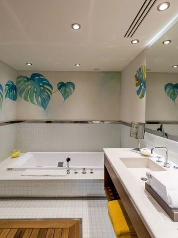 Modernes Badezimmer mit großer Badewanne, dezente Dekoration, helle Beleuchtung.