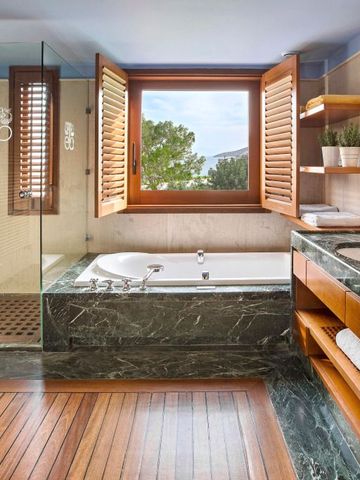 Luxuriöses Bad mit Marmorelementen, Jacuzzi, große Fenster.