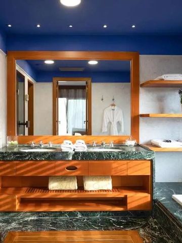 Luxusbadezimmer mit blauem Deckenakzent und grünem Marmorboden