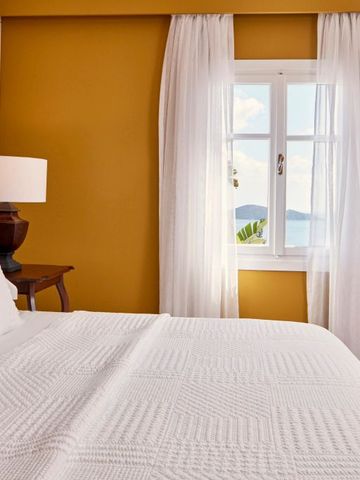 Zimmer mit gelben Wänden und Fensterblick aufs Meer