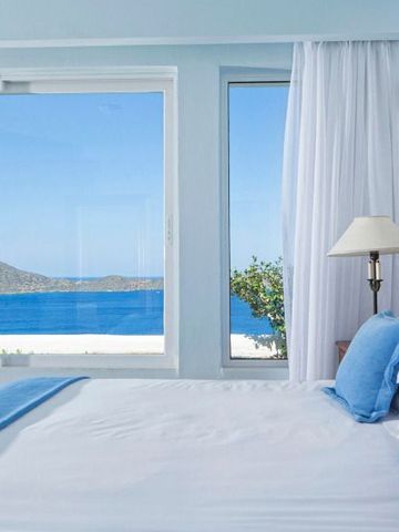 Zimmer mit großen Fenstern und Blick auf das Meer