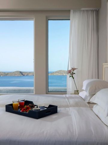 Schlafzimmer mit großem Fenster und Meerblick. Frühstückstablett auf dem Bett