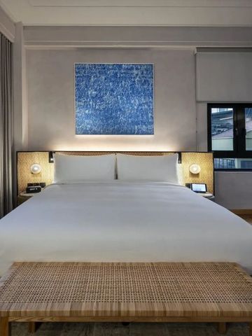 Modernes Hotelzimmer mit Kunstwerk und luxuriösem Kingsize-Bett