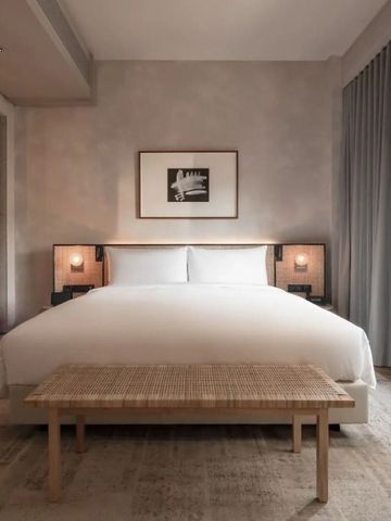 Geräumiges Hotelzimmer mit minimalistischer Einrichtung und warmen Tönen
