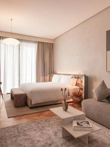 Gemütliche Hotelsuite mit Sofa, Kunstwerk und luxuriösem Bett