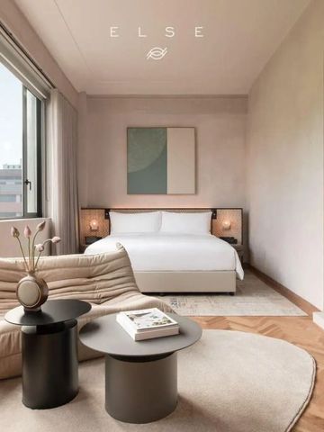 Helles Hotelzimmer mit modernem Design, großem Bett und gemütlicher Sitzecke.