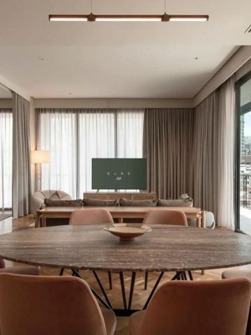 Geräumige Suite mit großem Esstisch, Sofa und weitem Blick durch Vorhänge.