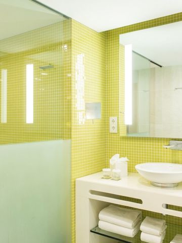 Modernes Badezimmer mit gelben Fliesen und stilvollem Waschbecken