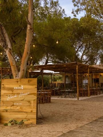 Holzterrasse vor einem Restaurant am Strand mit Lichterketten