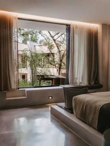 Geräumiges Zimmer mit großem Fenster und Blick ins Grüne